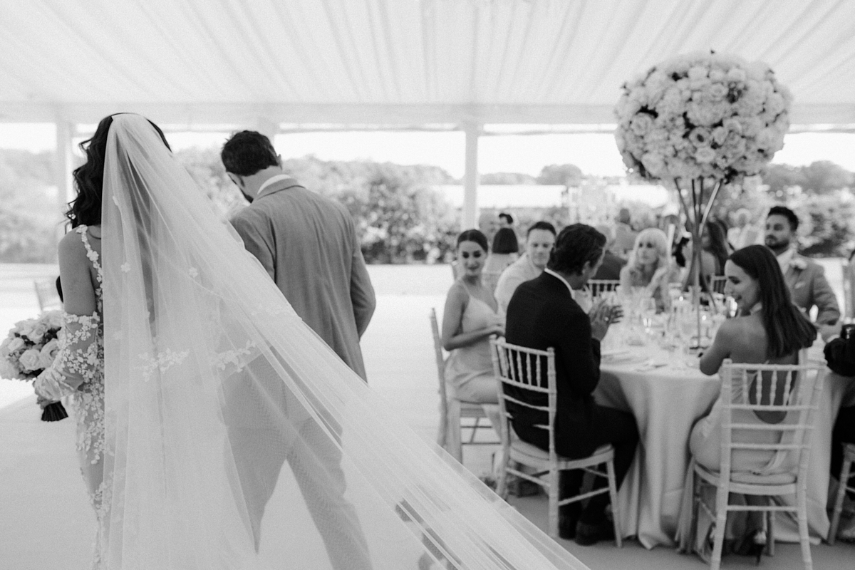 black and white photo of bride and groom entering wedding reception