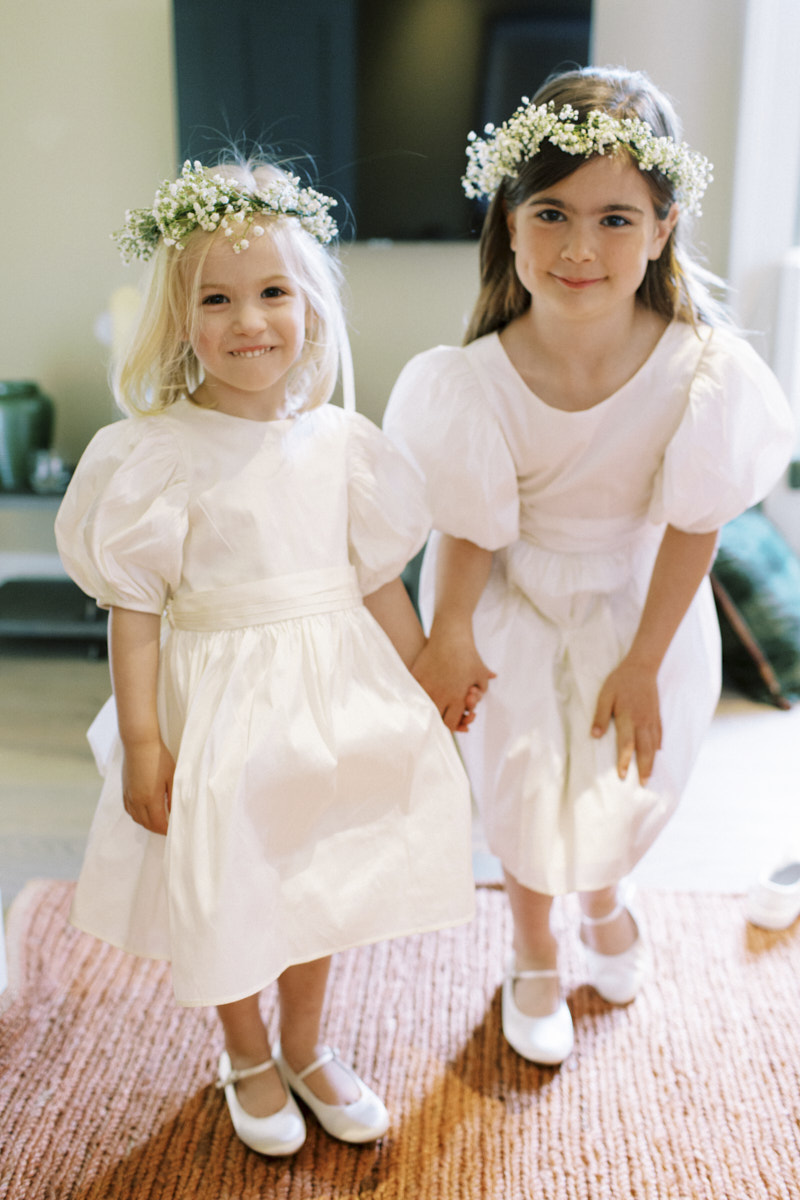 beautiful flowers girls wearing gypsophila flower crowns and wearing white taffeta bridesmaids dresses 