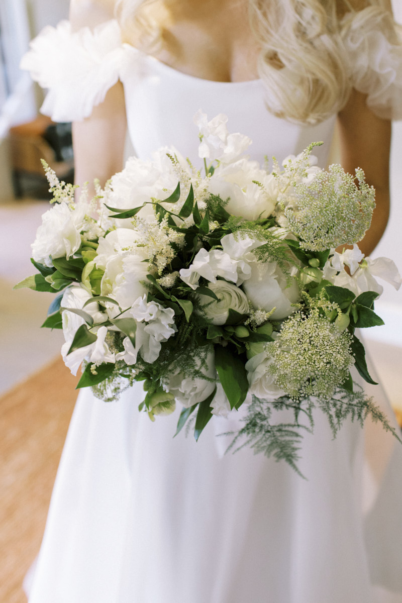 bride holding beautiful whimsical wedding flower bouquet in white 