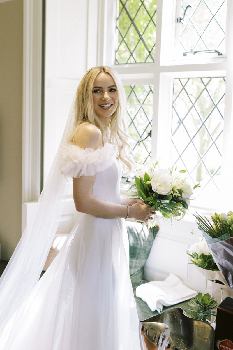 candid moment of the bride inside the cottage in the falcon hotel in castle ashby