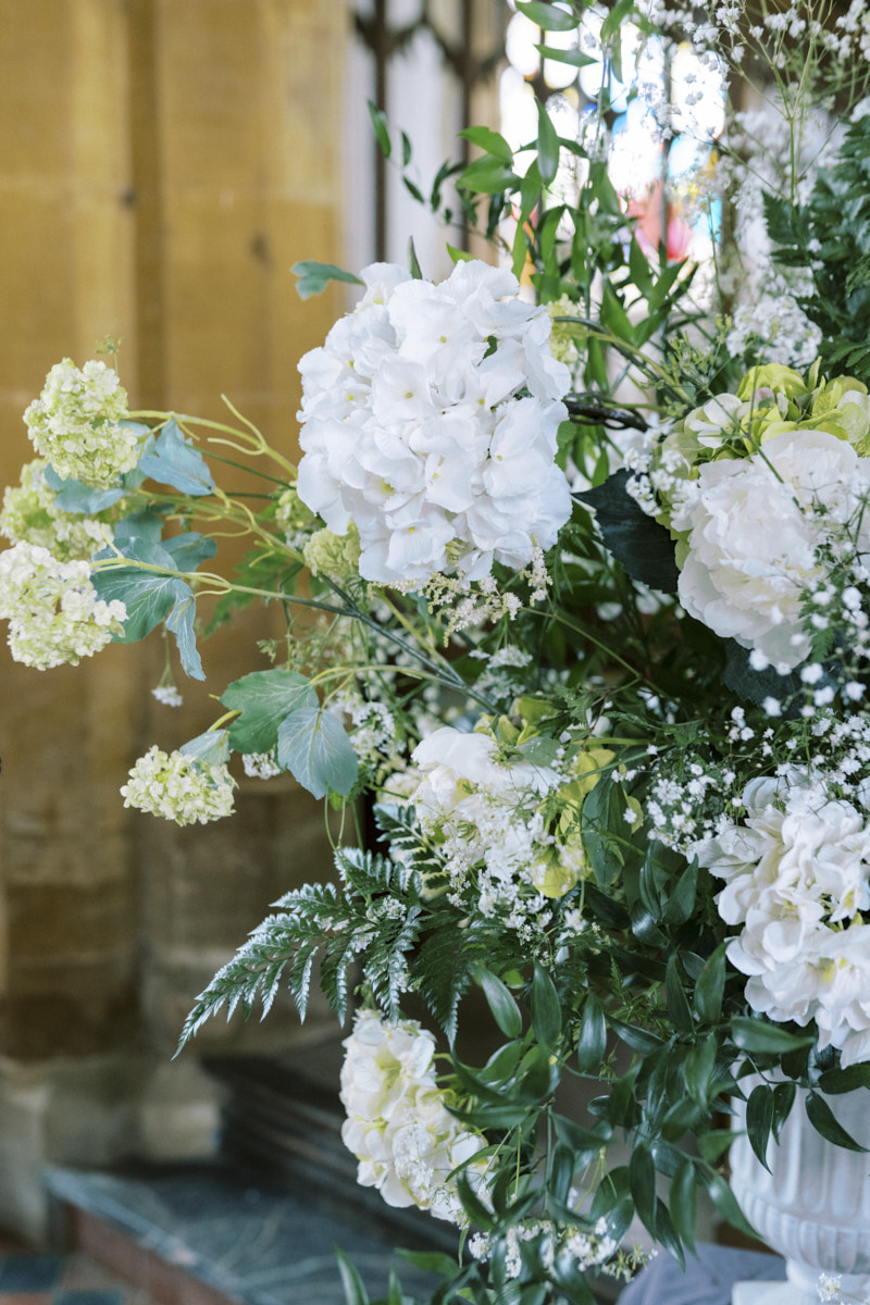 white wedding flower arrangements in st mary magdalene church in castle ashby