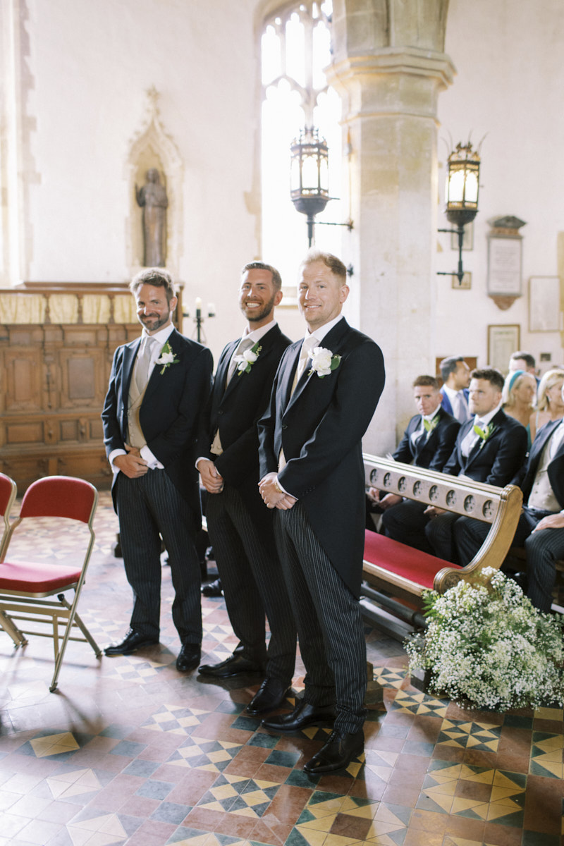 groom and groomsmen patiently waiting for the bride walking down the isle