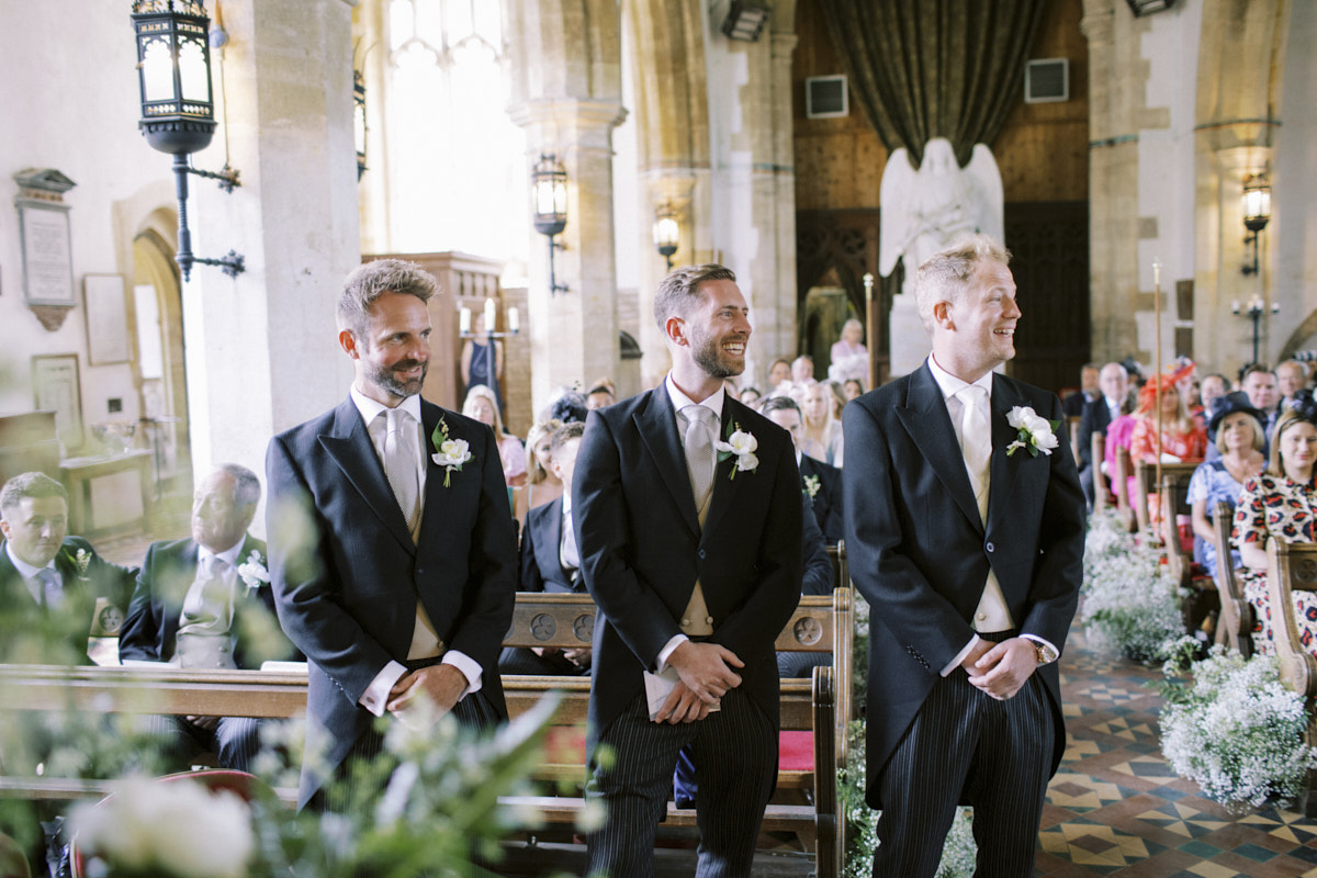 relaxed and natural photo of the groom and groomsmen looking at the wedding guests