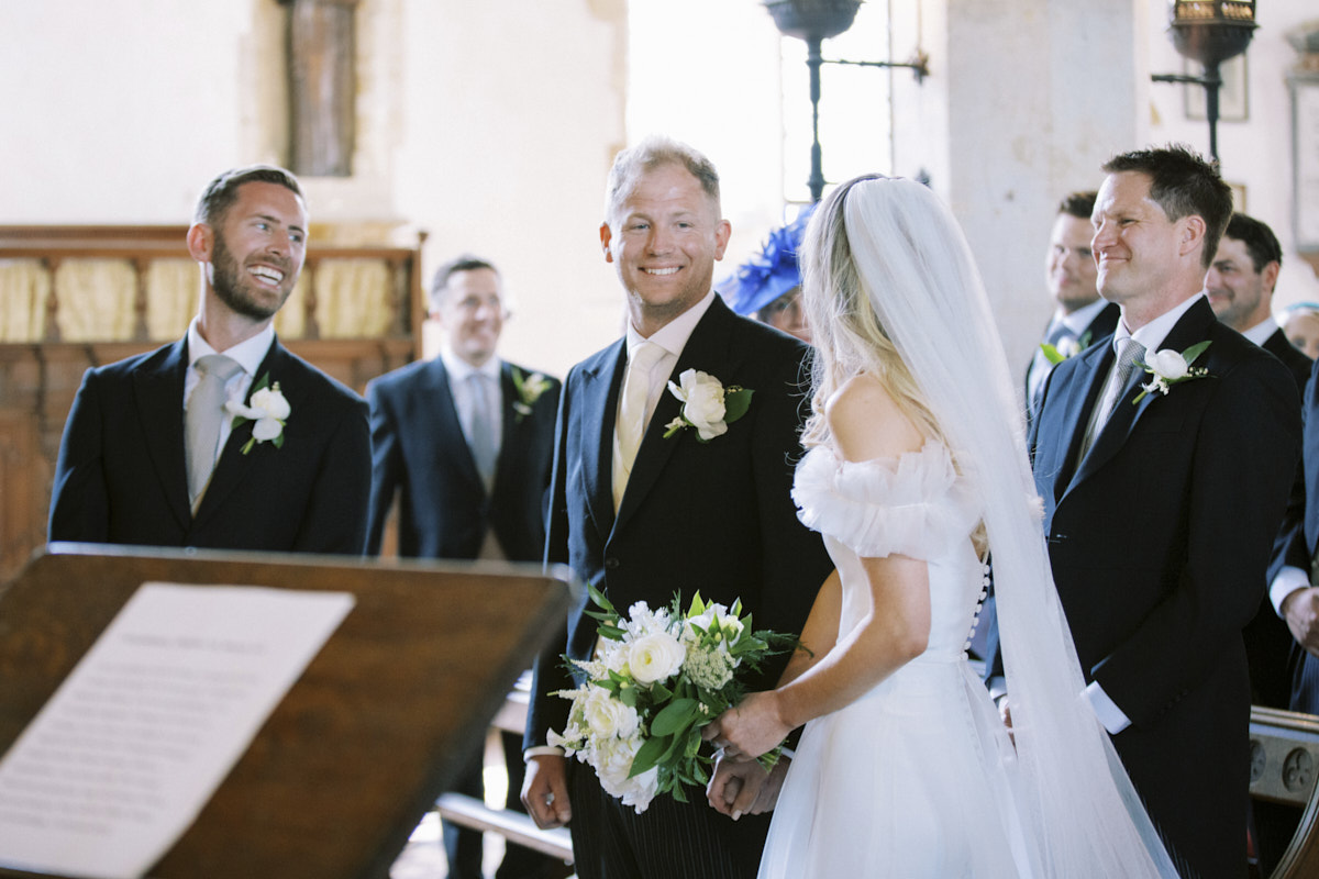 natural moment of the groom looking at the bride at church wedding in northampton