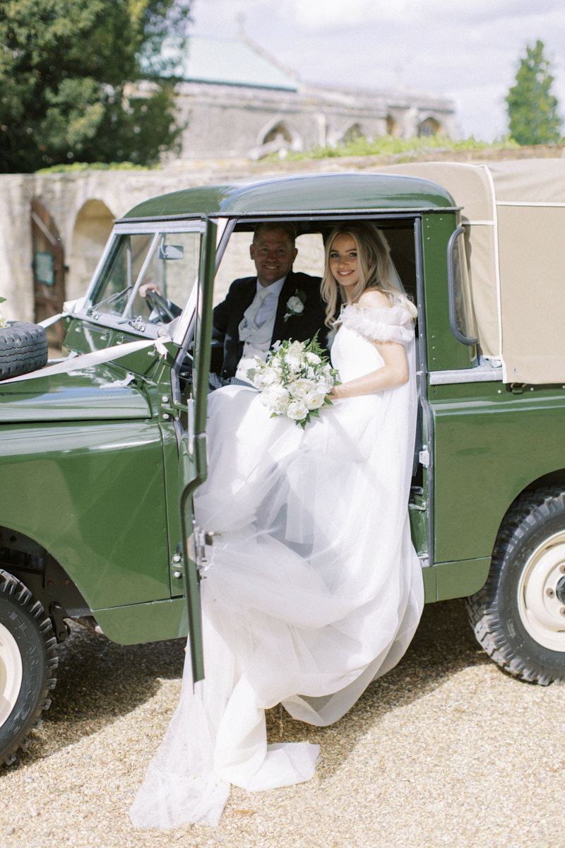 happy and relaxed bride and groom in the range rover wedding car