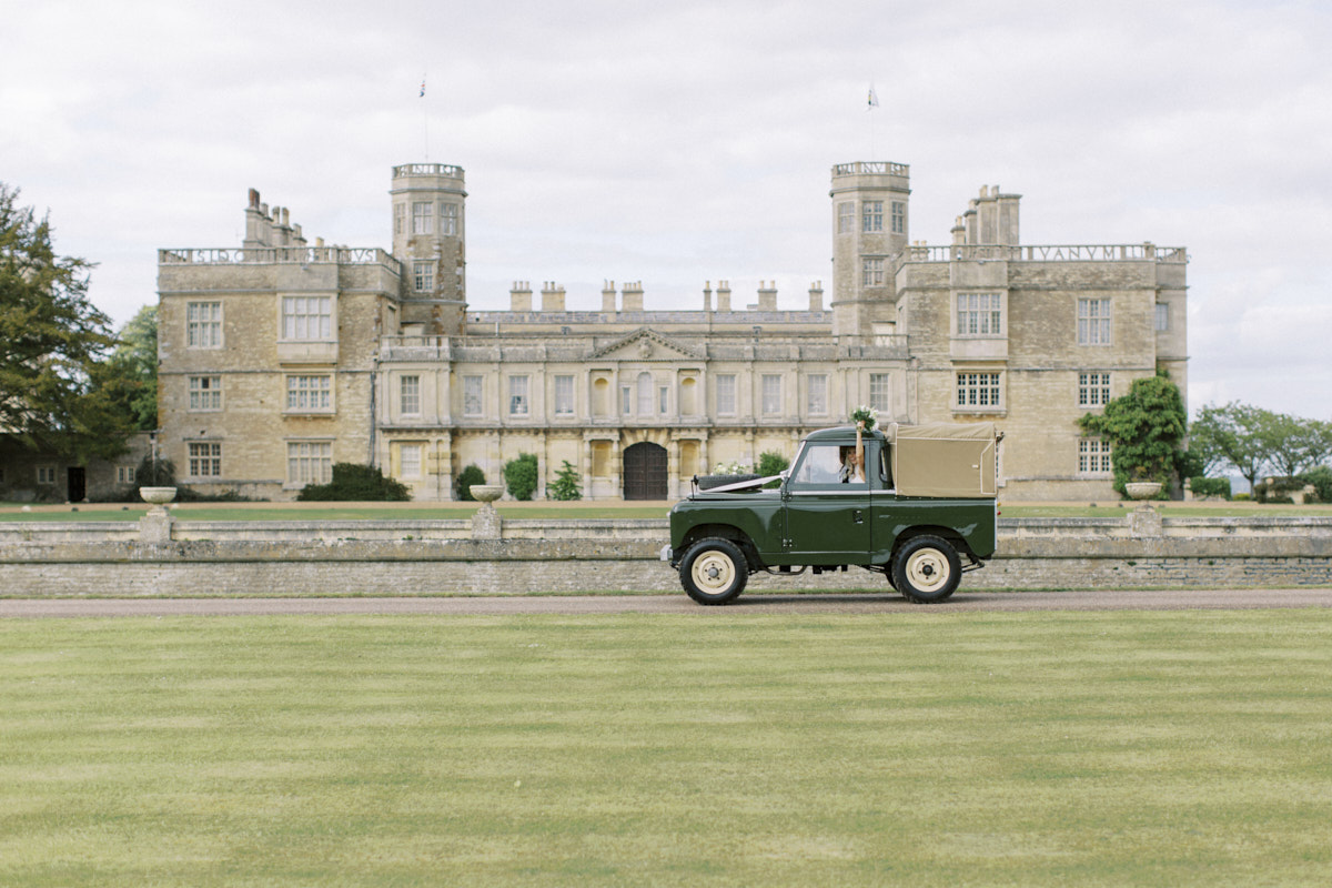 wedding car in front of the castle ashby house