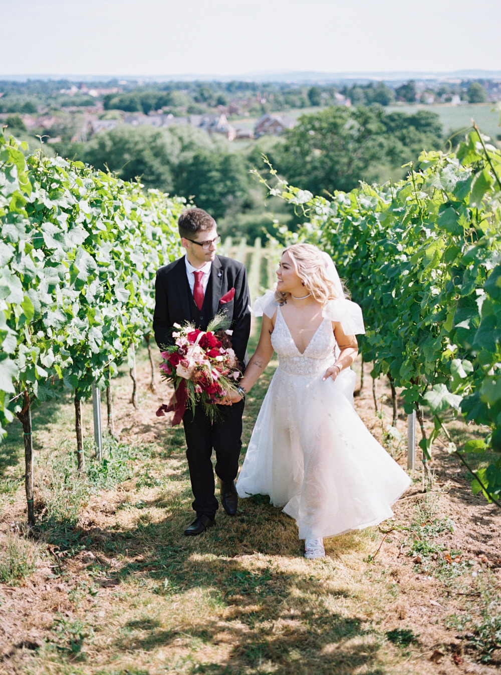 bride and groom walking holding hands and looking at each other at hencote vineyard