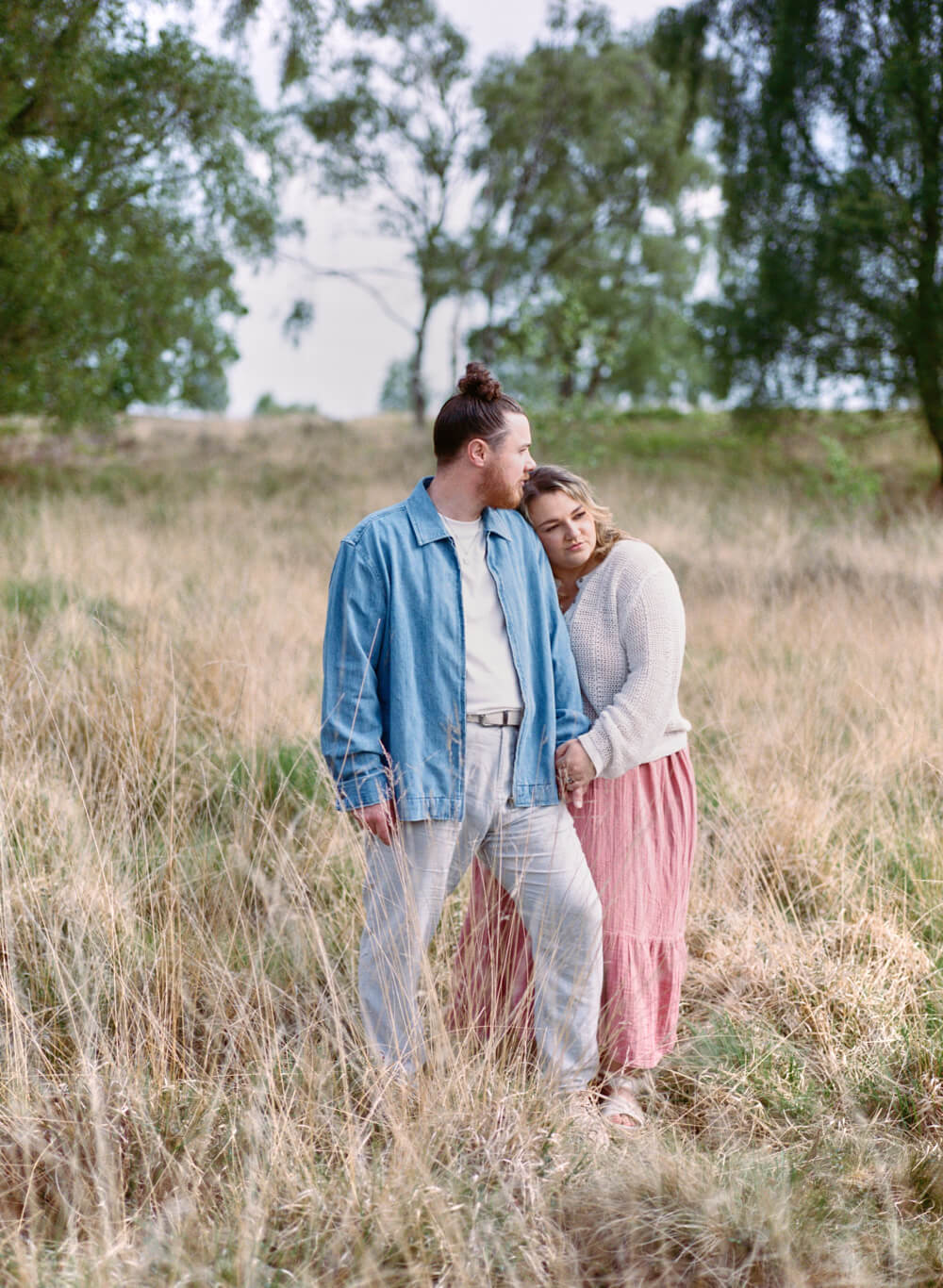 couple standing in long grass at park at their pre-wedding photoshoot