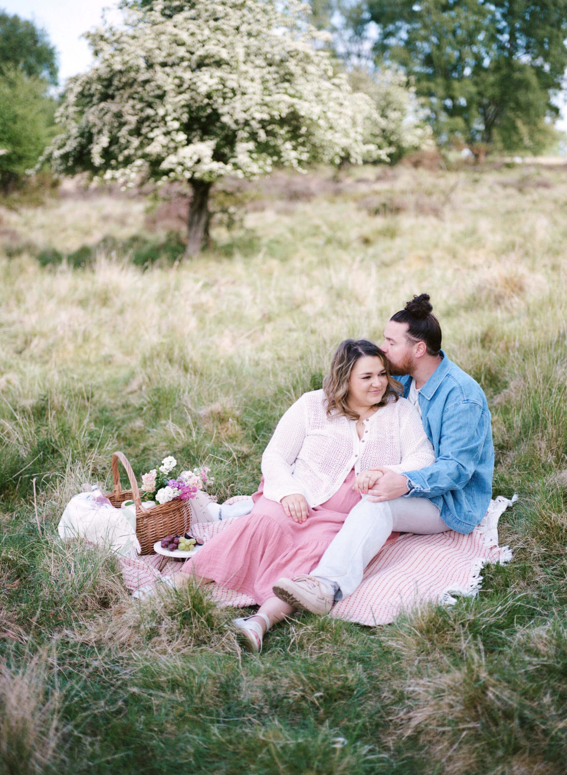 couple sitting on the picnic blanket at park